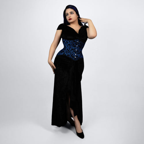Woman wearing a black evening gown with blue sequin details on a white background